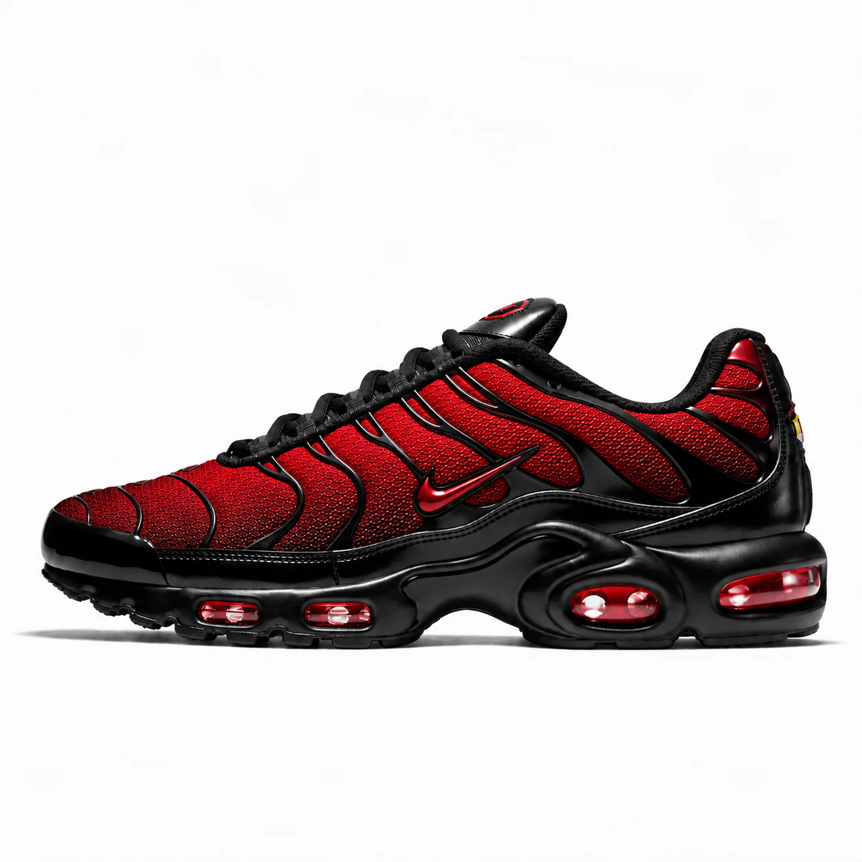 Nike Air Max Plus in black, red, side view of the sneaker on a white background.
