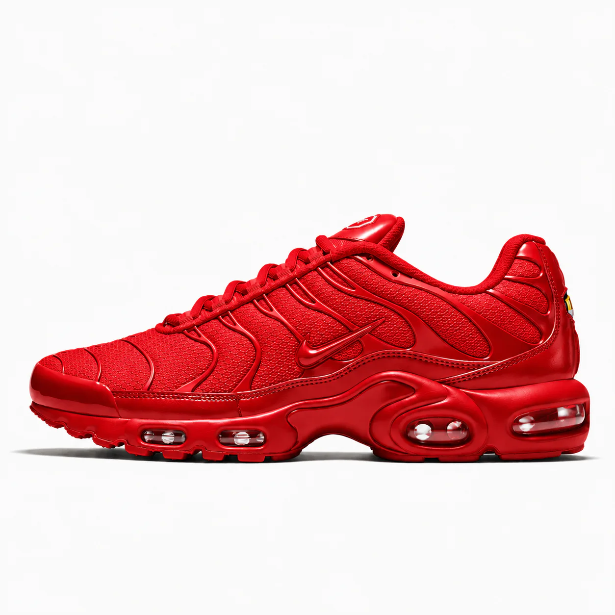 Nike Air Max Plus in red, side view of the sneaker on a white background.