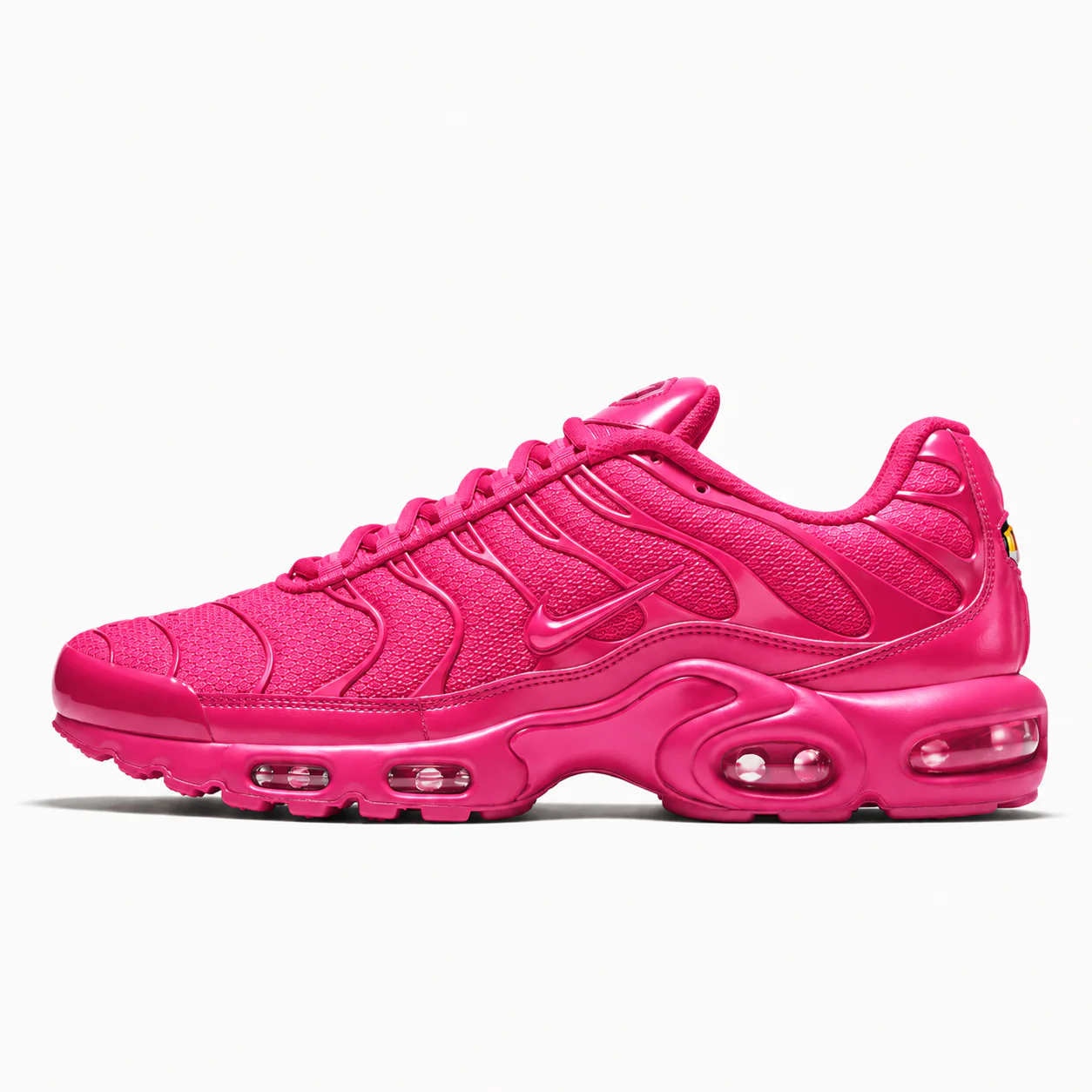 Nike Air Max Plus in hot pink, side view of the sneaker on a white background.